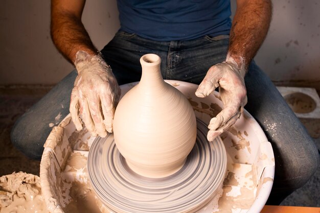 Potier professionnel faisant un bol dans un atelier de poterie