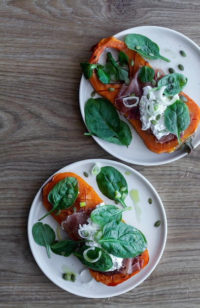 Photo potiron rôti au ricotta, jambon serrano, épinards et oignons