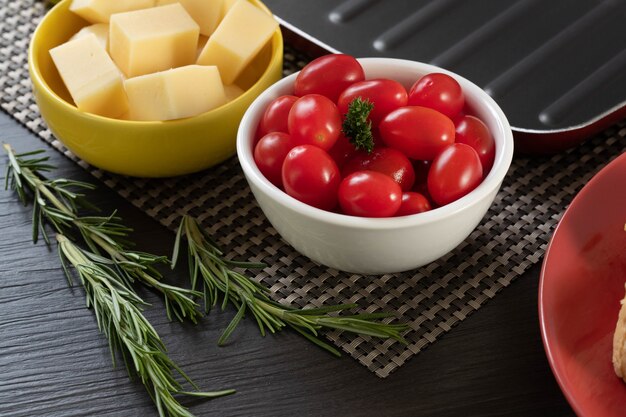 Pots d'apéritif avec du fromage et des tomates cerises.