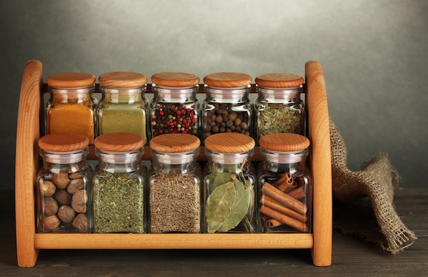 Pots d'épices sur étagère sur table sur fond gris