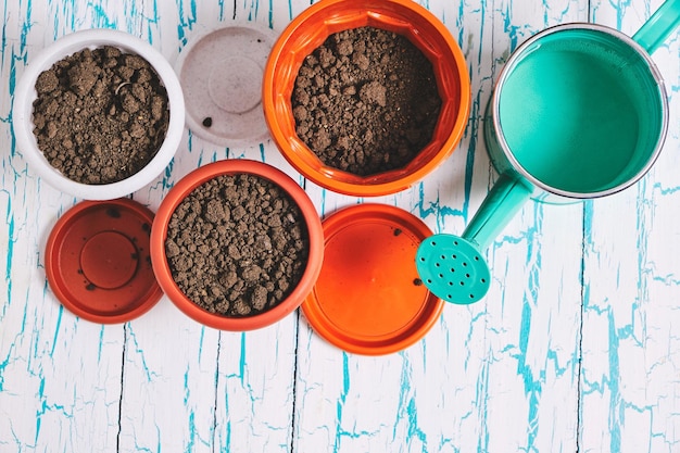 Pots de fleurs et arrosoir vue de dessus de fond en bois décoratif