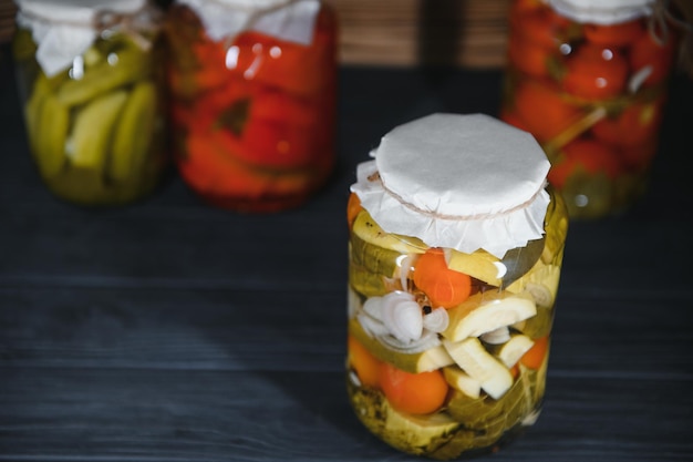 Pots de légumes marinés sur fond de bois rustique