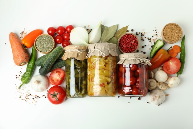 Pots de légumes marinés et ingrédients sur tableau blanc