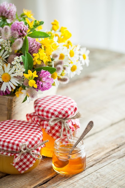 Pots de miel et bouquet d'herbes médicinales sur la table Mise au point sélective