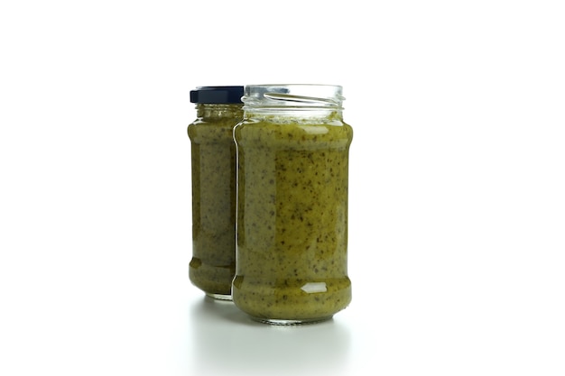 Pots de sauce pesto isolé sur fond blanc