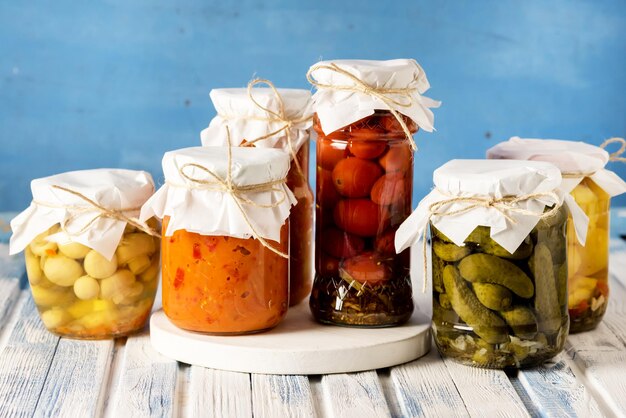 Pots de savoureux légumes marinés en conserve maison bleu et blanc sur fond de bois