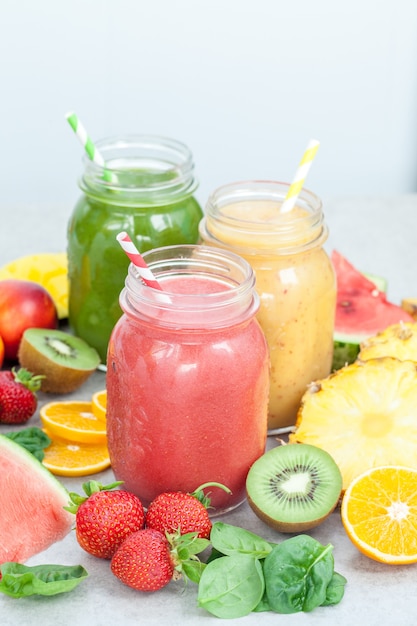 Pots de smoothie entourés de fruits et de baies en tranches