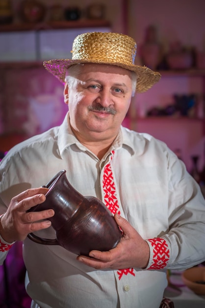 Potter avec une cruche se tient dans son atelier