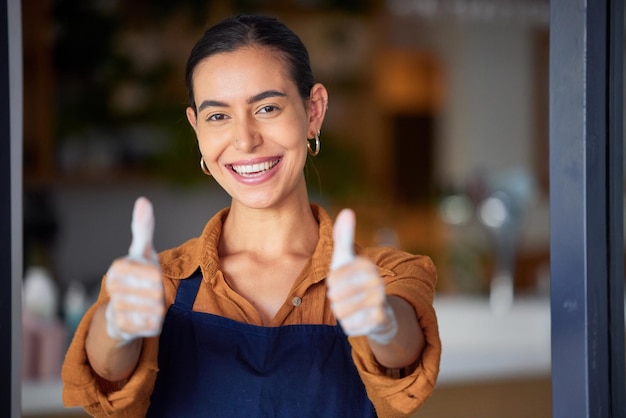 Pouce en l'air petite entreprise et propriétaire d'un café ou d'un restaurant se sentant fier et prêt pour le service à la porte de son magasin