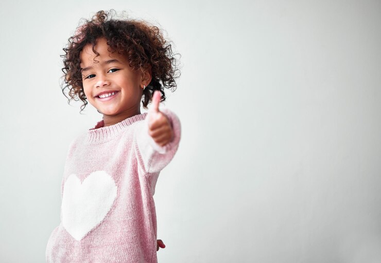 Photo pouce haut enfant ou portrait sur l'espace de studio pour oui approbation ou heureux pour l'accord fille geste de la main ou sourire sur fond blanc pour le choix merci ou appréciation avec positivité au brésil