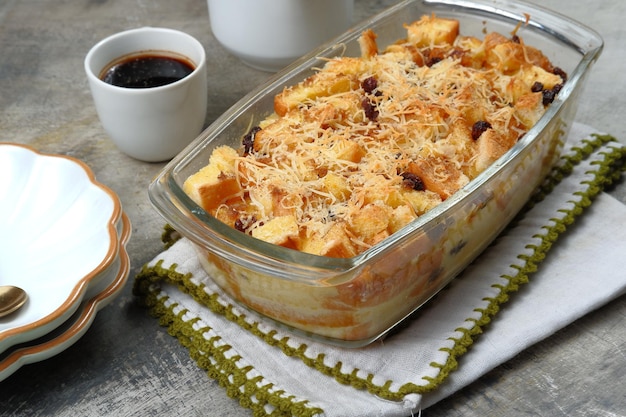 Pouding au beurre de pain fait maison avec des raisins secs et du fromage râpé comme garniture