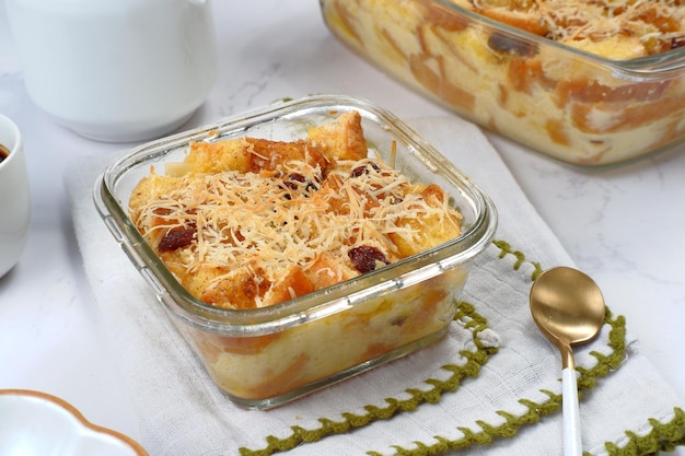 Pouding au beurre de pain fait maison avec des raisins secs et du fromage râpé comme garniture