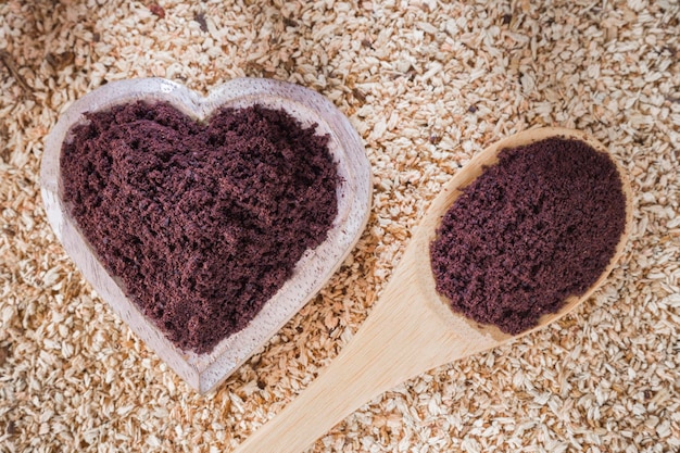 Poudre d'açai dans un bol sur fond de bois