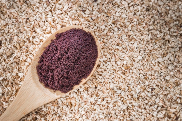 Poudre d'açai dans un bol sur fond de bois