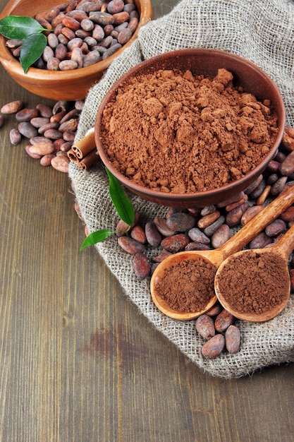 Poudre de cacao et fèves de cacao sur fond de bois