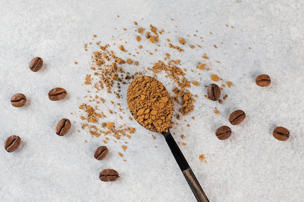 Poudre de café instantané dans une cuillère sur une bannière d'espace de copie de fond gris