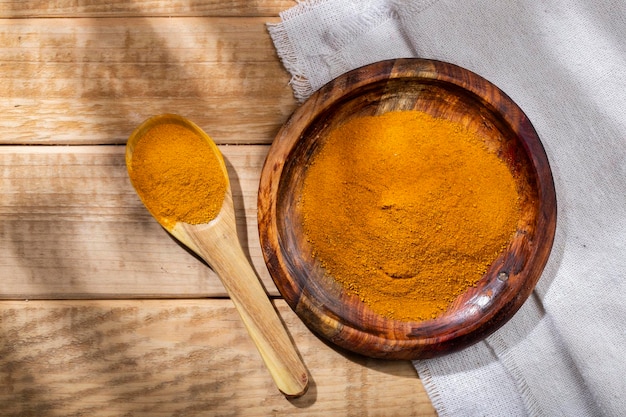 Poudre de curcuma dans un bol sur la vue de dessus de table