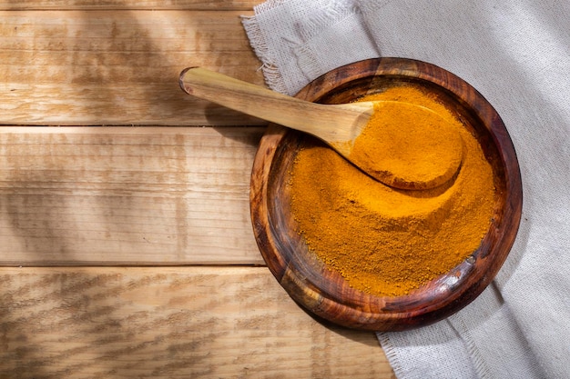 Poudre de curcuma dans un bol sur la vue de dessus de table