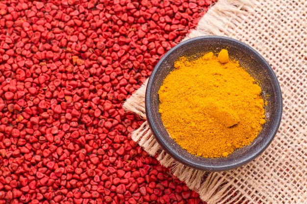 Poudre de curcuma et graines d'achiote dans un récipient