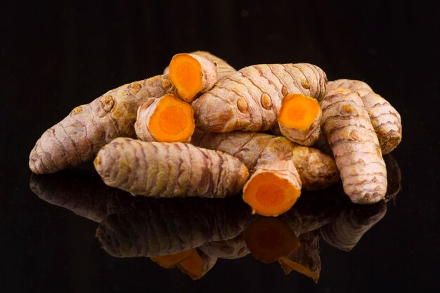 Poudre de curcuma et racines sur fond en bois