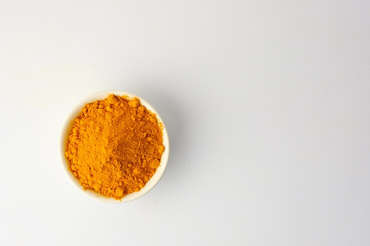 Poudre de curcuma sec isolé sur fond blanc.Gros plan de poudre de curcuma de couleur orange.Vue de dessus et espace copie
