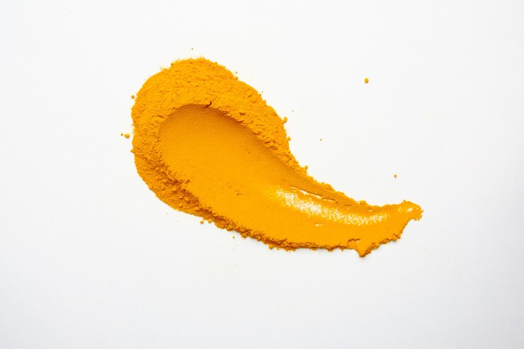 Poudre de curcuma sec isolé sur fond blanc. Gros plan de poudre de curcuma de couleur orange. Vue de dessus