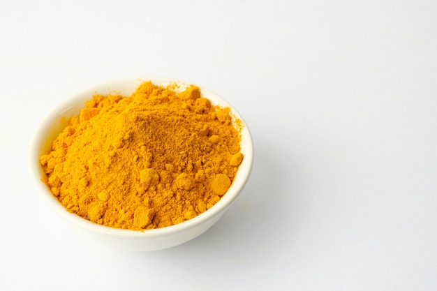 Poudre de curcuma sec isolé sur fond blanc. Gros plan de poudre de curcuma de couleur orange. Vue de dessus