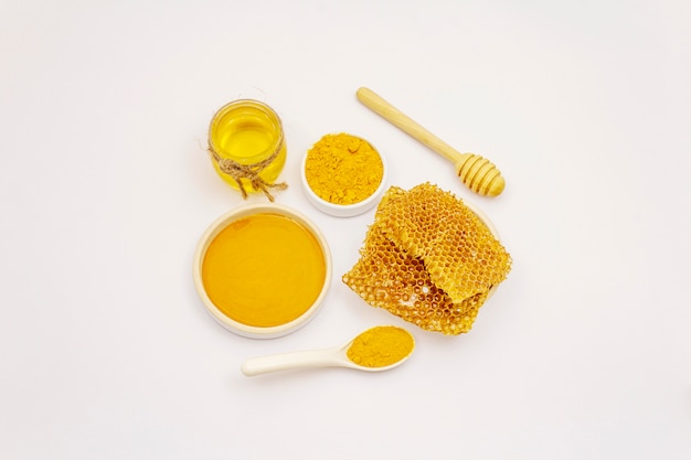 Poudre de curcuma sec, miel et nids d'abeille isolé sur fond blanc