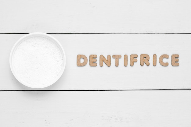 Poudre dentaire sur blanc avec mot dentifrice