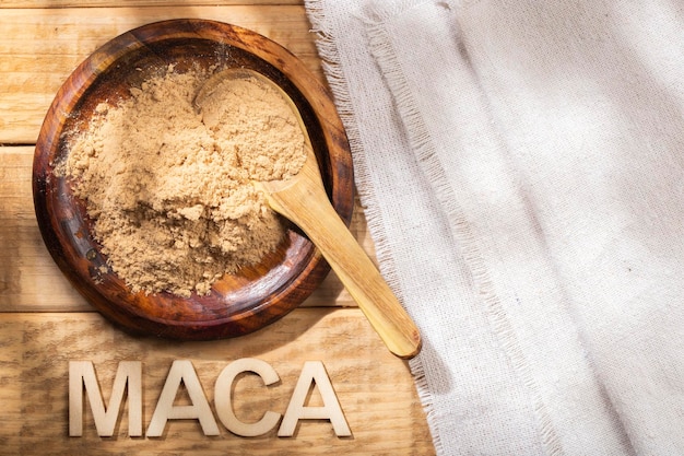 Poudre de maca dans un bol en bois sur la table substance nutritive du Pérou