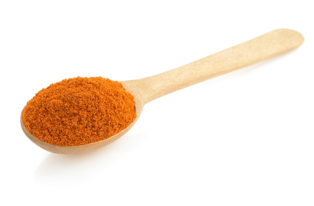 Poudre de paprika et cuillère isolé sur blanc