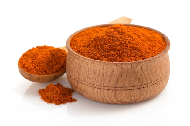 Poudre de paprika et cuillère isolé sur fond blanc