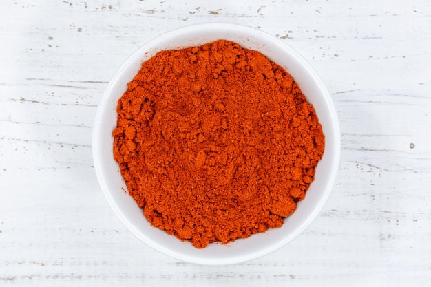 Poudre de paprika red hot d'au-dessus de la planche de bois bol