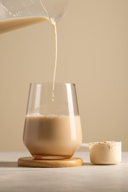 Poudre de protéines Verser une boisson au chocolat dans un verre