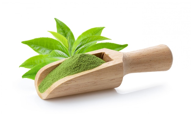 Poudre de thé vert matcha en cuillère en bois avec feuille sur blanc