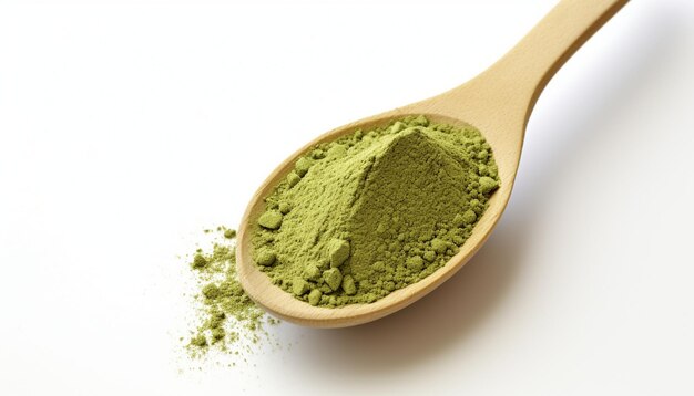 Poudre de thé vert matcha dans une cuillère en bois isolée sur fond blanc