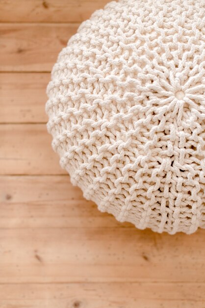 pouf tricoté sur fond de bois