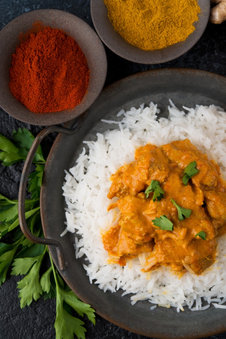 Photo poulet au curry avec du riz et des épices - un plat traditionnel indien populaire