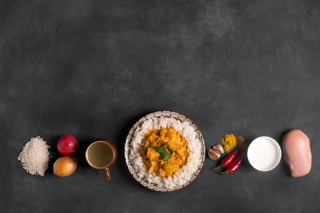 Poulet au curry avec du riz et des ingrédients au tableau noir. Espace copie vue de dessus. Orientation horizontale