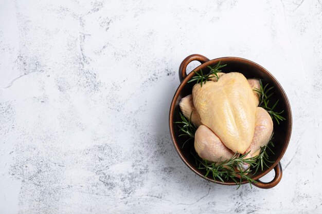 Poulet cru aux herbes dans un bol pour le texte.