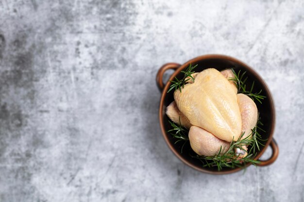 Poulet cru aux herbes dans un bol pour le texte.