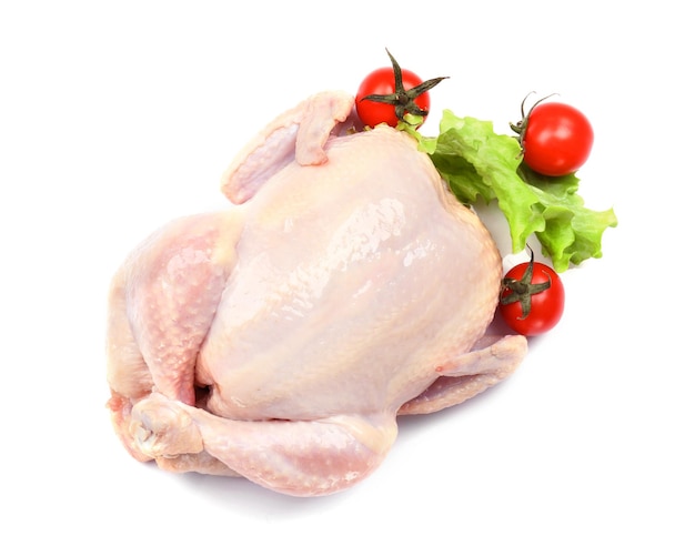 Photo poulet cru entier avec laitue et tomate sur fond blanc