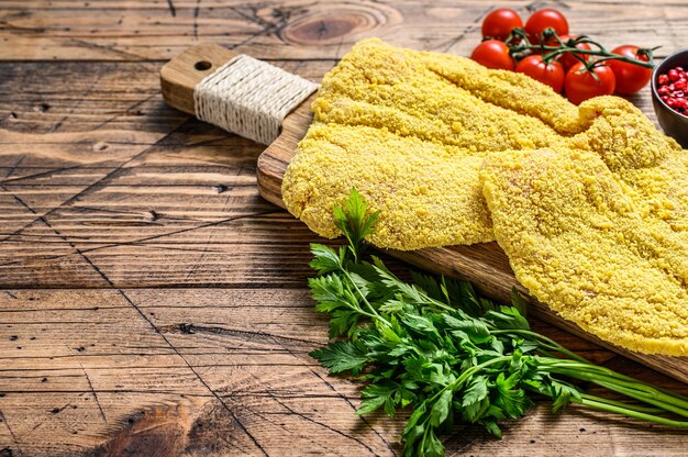 Poulet cru pané Weiner Schnitzel. table en bois. Vue de dessus.