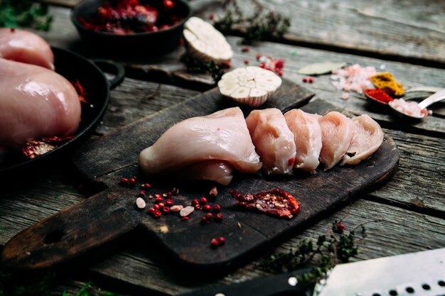 Poulet cru sur une table en bois avec des épices