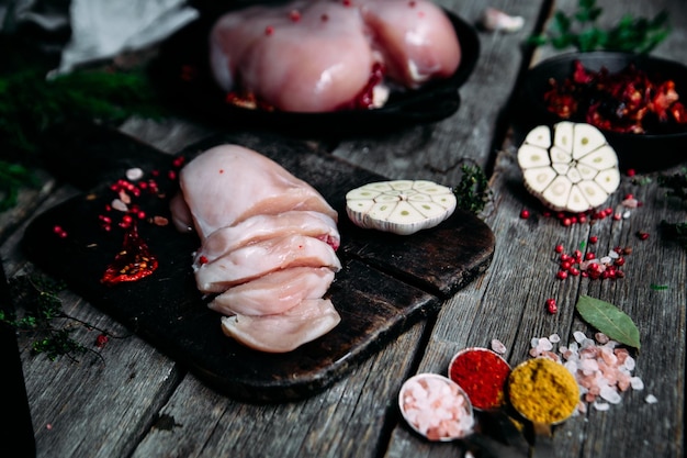 Poulet cru sur une table en bois avec des épices