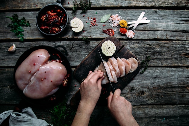 Poulet cru sur une table en bois avec des épices