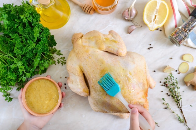 poulet cru sur la table avec des ingrédients pour la marinade