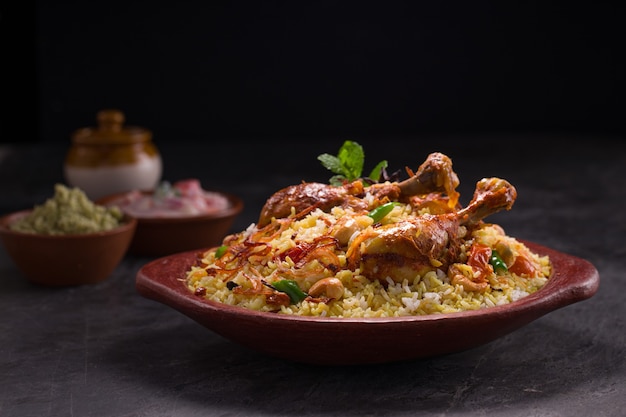 Poulet dhum biriyani à l'aide de riz jeera et d'épices disposés dans de la terre cuite