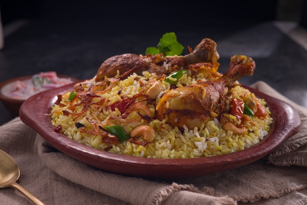 Poulet dhum biriyani à l'aide de riz jeera et d'épices disposés dans de la terre cuite