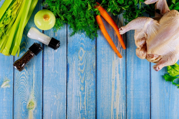 Poulet entier cru avec des légumes préparés pour la soupe.